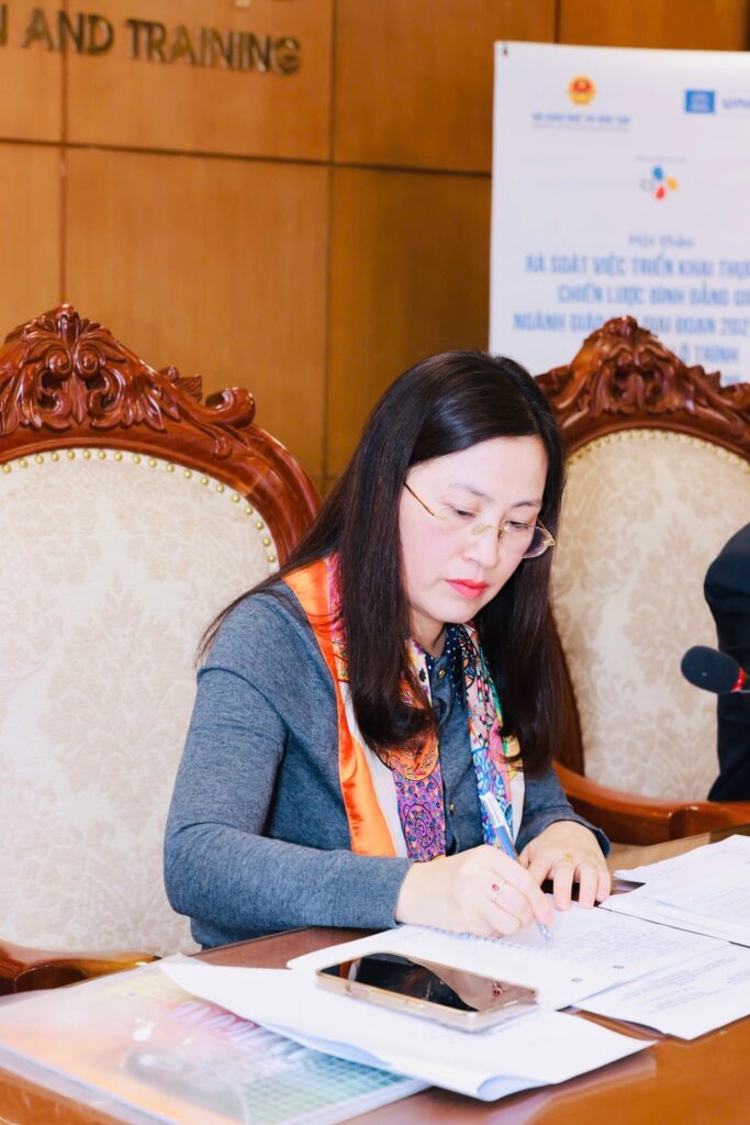 Portrait of Dr. Le Thi Mai Hoa, Deputy Director General of the Department of Education, Central Commission for Propaganda and Education, focused on note-taking at a symposium.